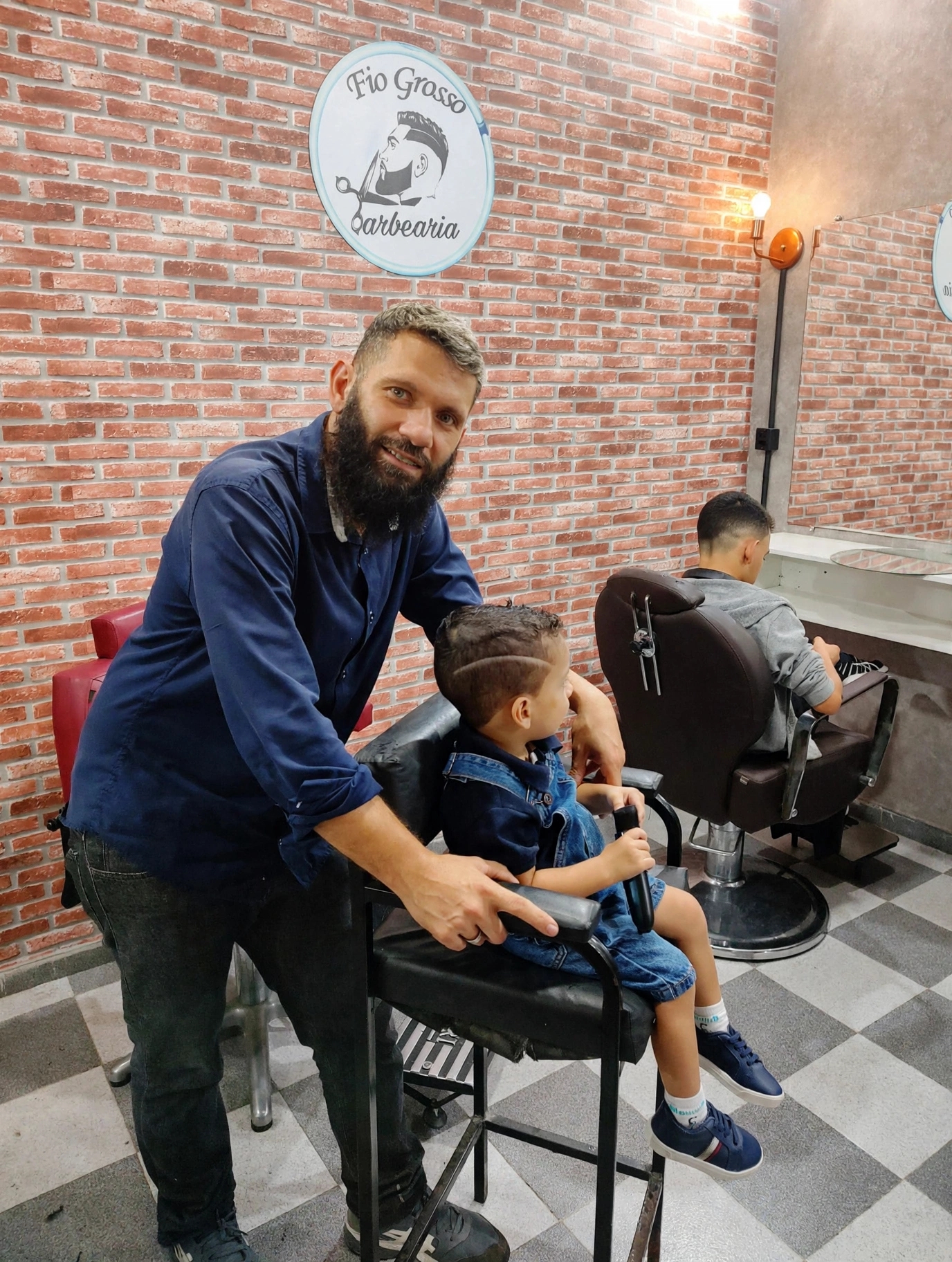 Barbeiro com cliente mirim na cadeira